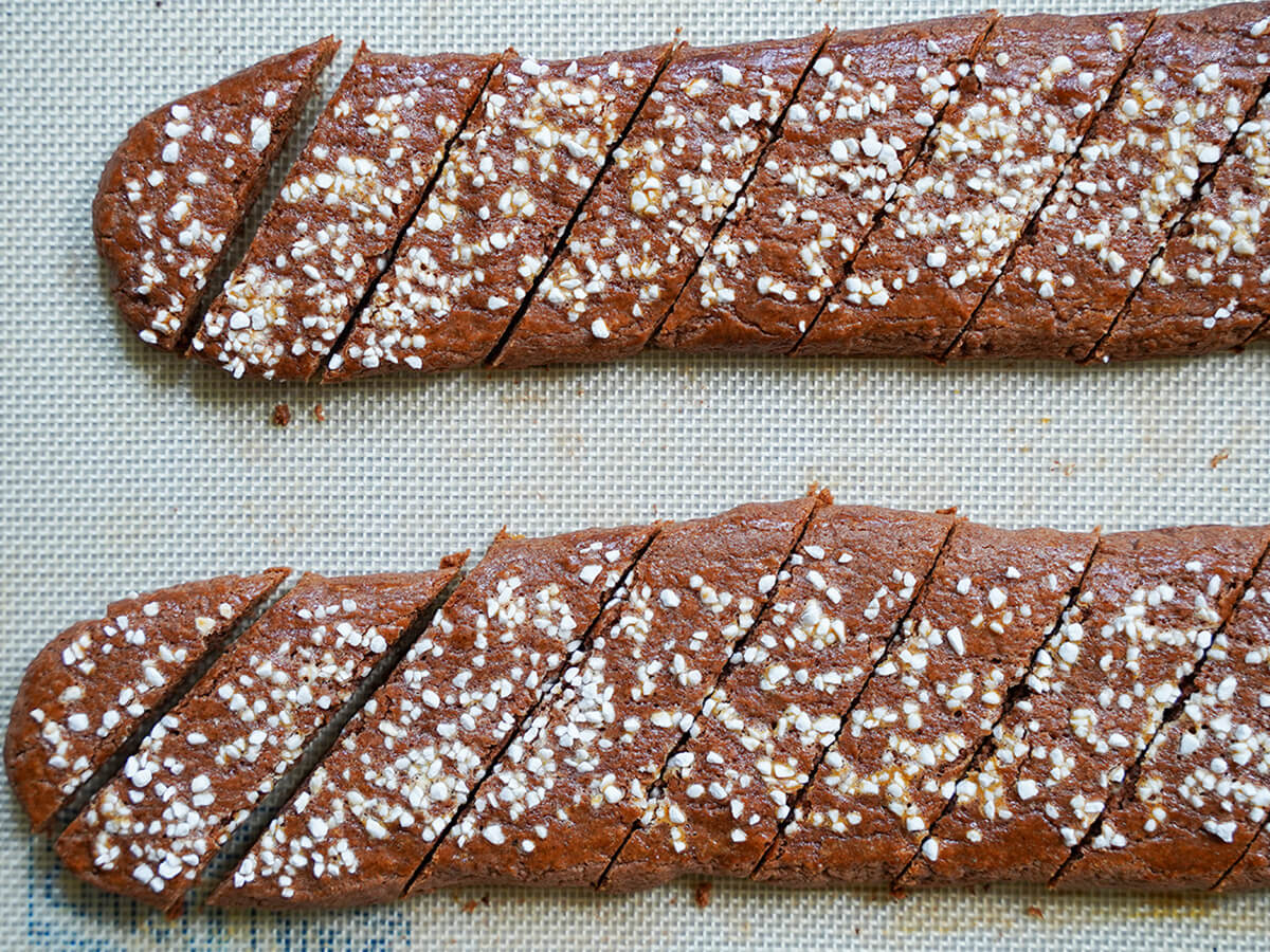 slicing chokladsnittar, Swedish chocolate cookie slices slicing baked chokladsnittar, Swedish chocolate cookies on baking mat.