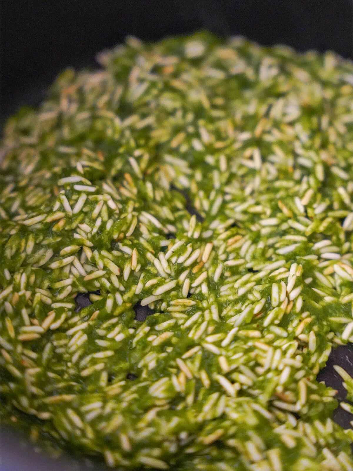 toasting rice with green puree while making arroz verde toasted rice with herby paste mixed in in bottom of pan.