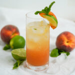 side view of glass of peach mojito.