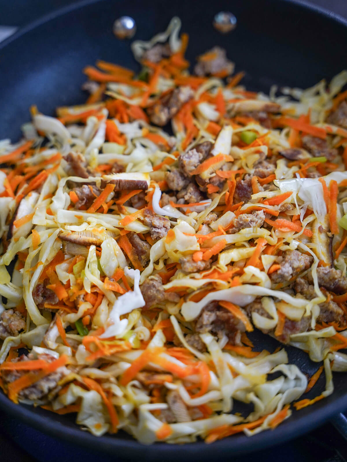 pork and vegetables cooking in pan.