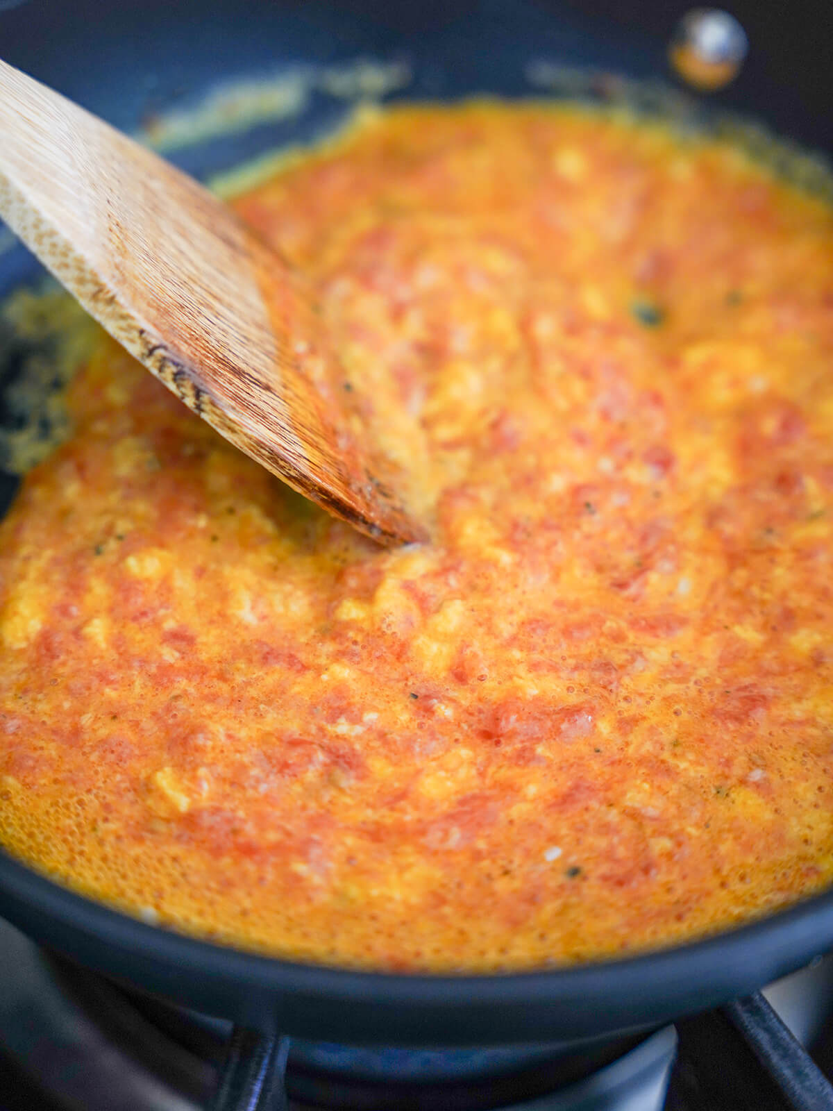 cooking egg and tomato together in skillet.