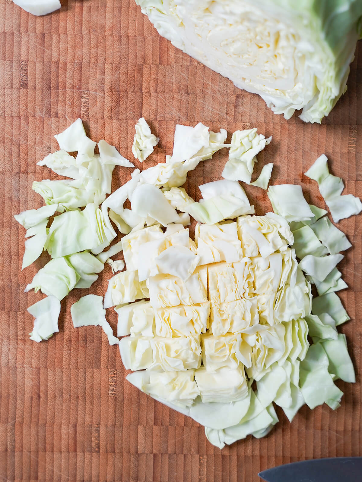 diced up cabbage on wooden board.