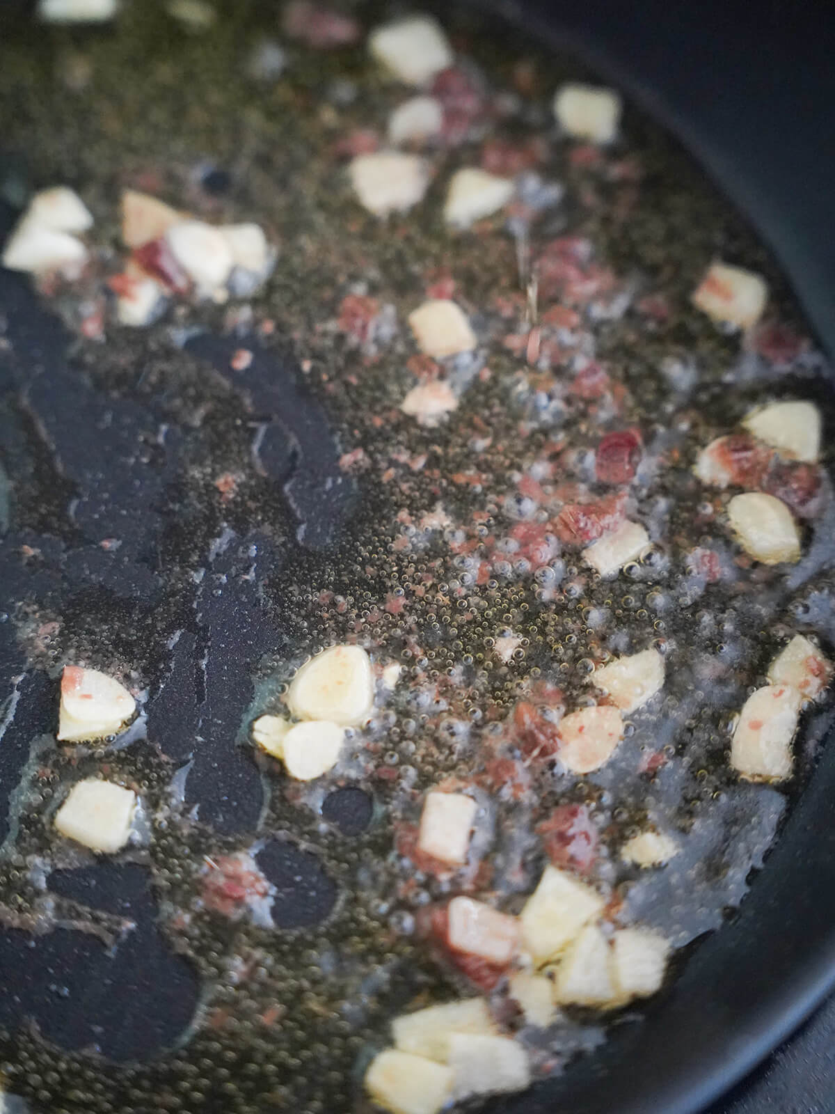 cooking garlic and anchovy in olive oil in skillet.