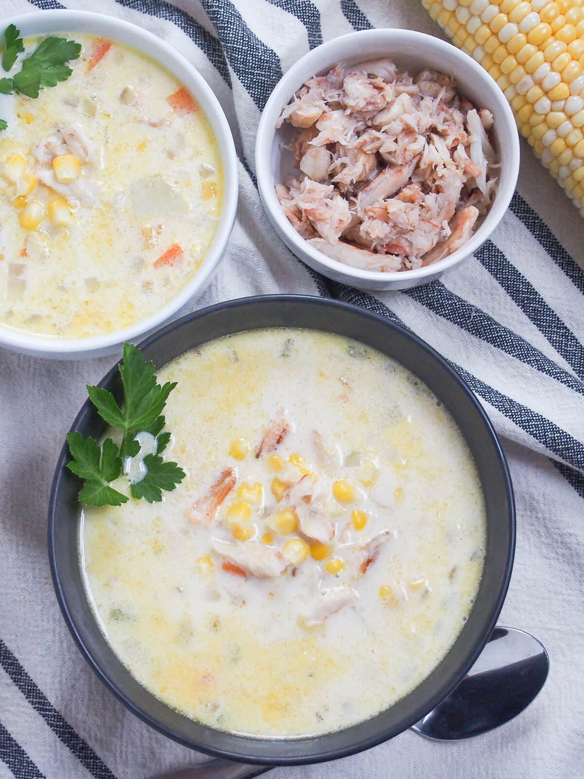 This crab and corn chowder is a delicious combination of flavors that's hearty, comforting and filling yet feels that bit lighter and indulgent with the crab and corn. Perfect for any occasion. overhead view of bowls of crab and corn chowder with small bowl of crab above