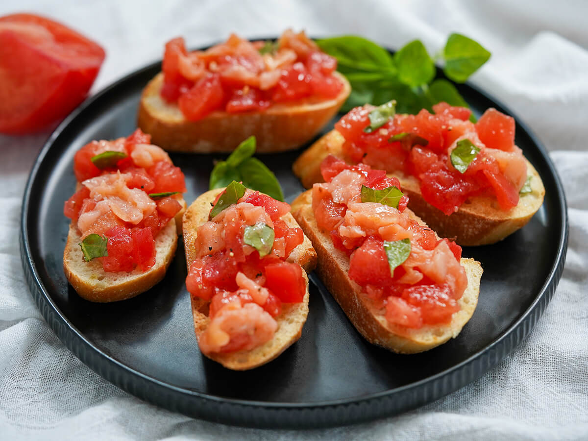 A light and delicious appetizer, this smoked salmon bruschetta is a simple twist on a classic. It's great for any occasion and quick to prepare. side view of plate of smoked salmon bruschetta.