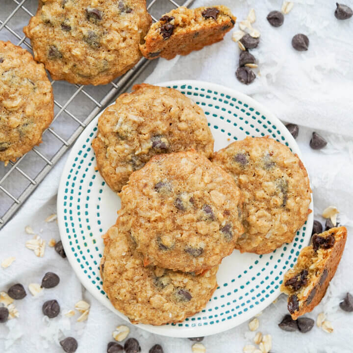 overhead view of small plate of coconut oatmeal chocolate chip cookies with cookie pieces resting to side.