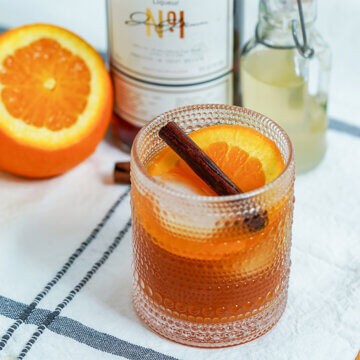 glass of Winter Pimms cup with orange behind.