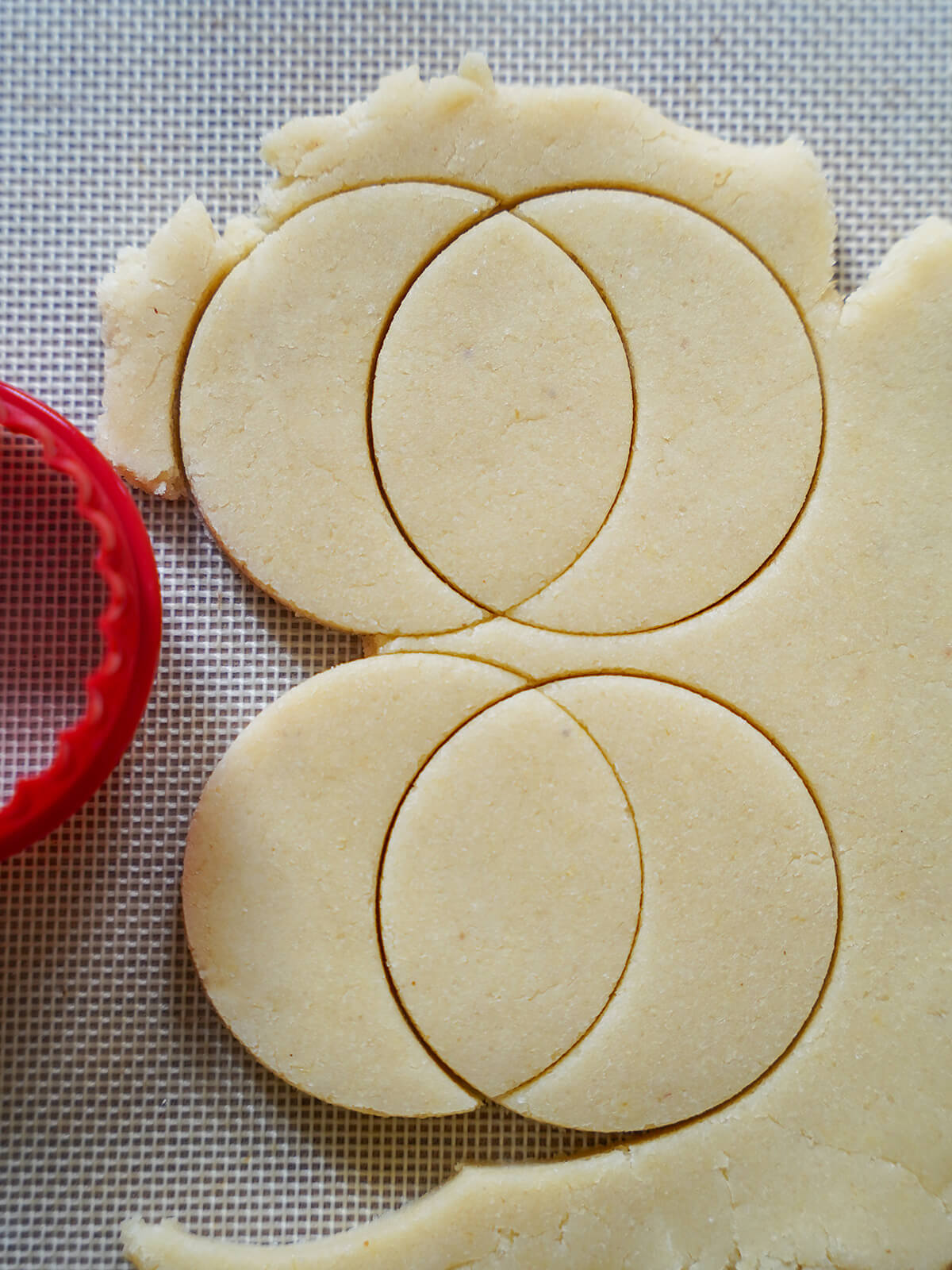 cutting lemon almond cookies Zedernbrot cutting moon shaped cookies from dough by using two circles overlapping.