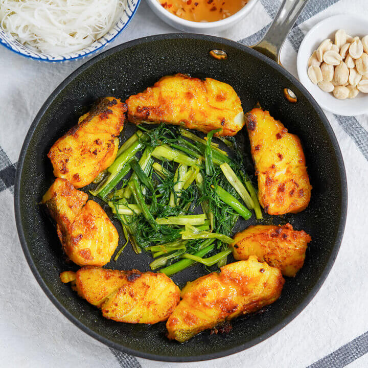 overhead view of skillet of Vietnamese turmeric fish, cha ca la vong.