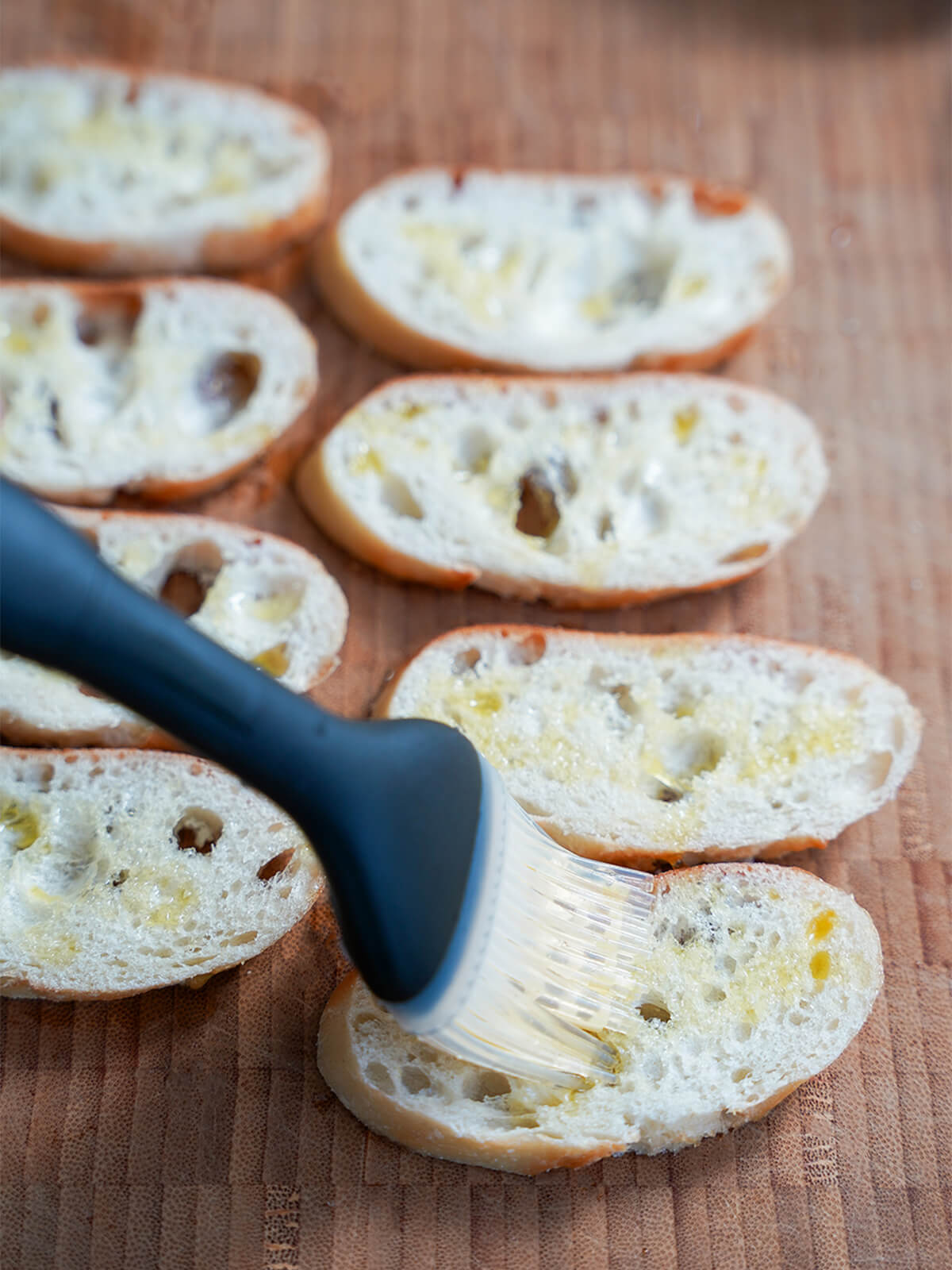 brushing thin slices of bread with olive oil.