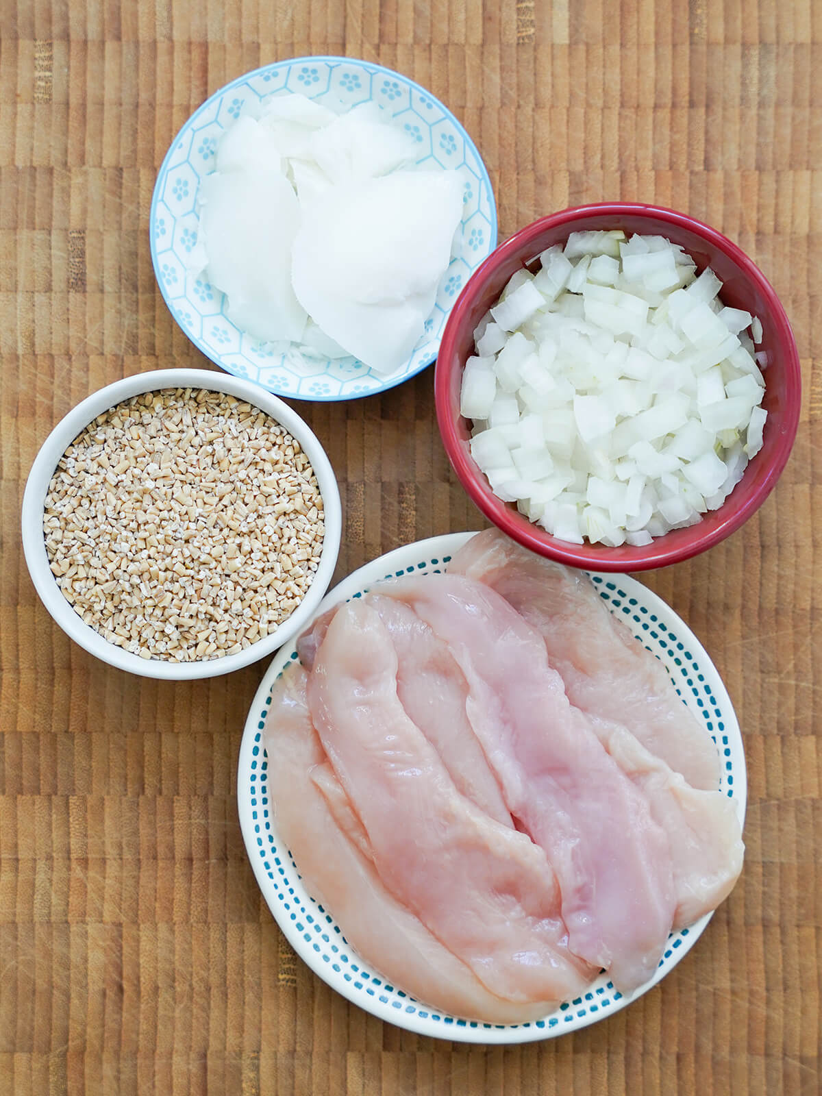 plate of chicken tenders, bowls with onion, pinhead oatmeal/steel cut oats, and dish of tallow.
