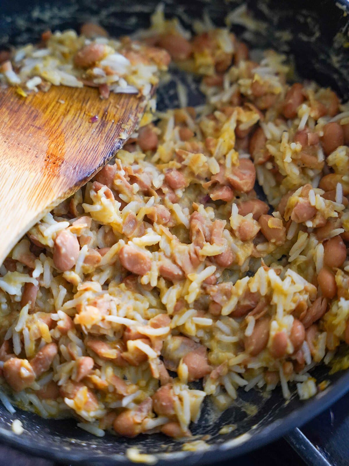 cooking tacu tacu mixture cooking rice and bean mixture in skillet.
