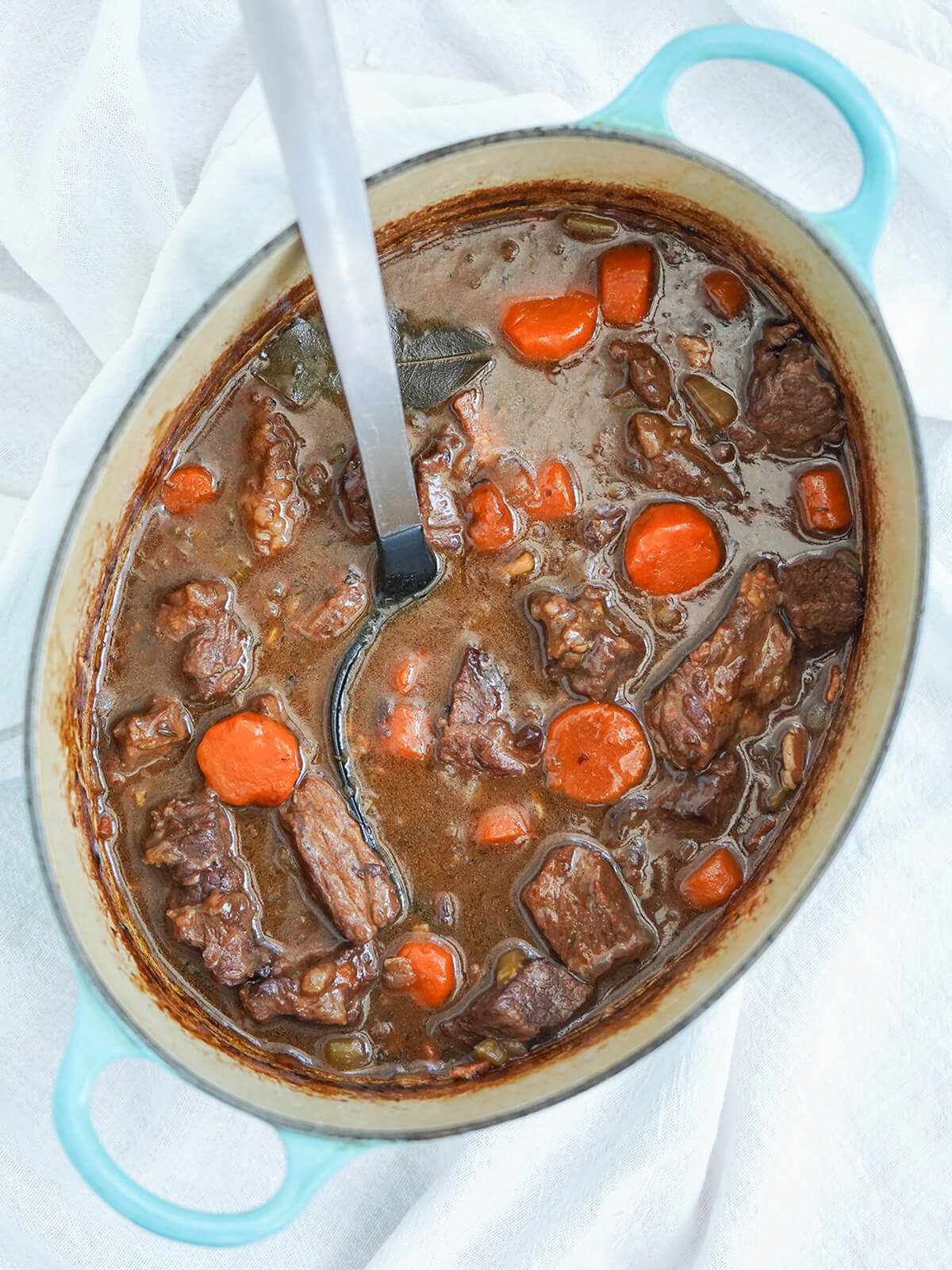 pot of Guinness beef stew with spoon in pot from overhead.