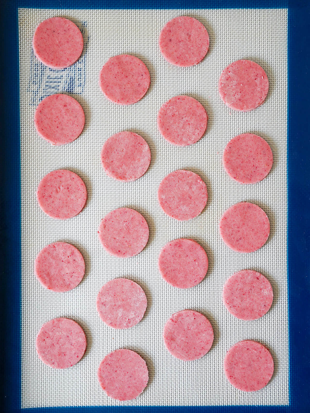 strawberry shortbread cookies before baking cut cookie circles in rows on lined baking sheet before baking.