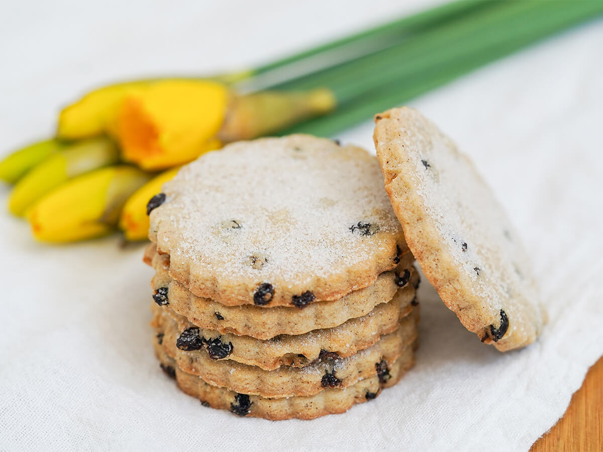 stack of Easter biscuits with one resting on side and daffodils to side and behind.