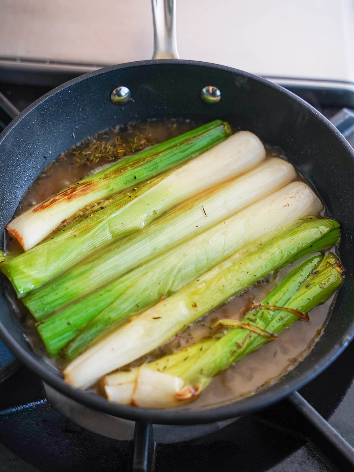 cooking leeks in skillet with butter and stock.