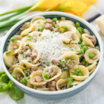 bowl of pea and lamb pasta topped with some grated cheese.