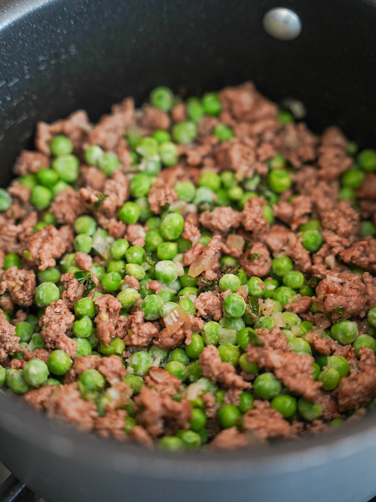 peas and ground lamb mixture in pot.