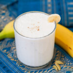 side view of glass of banana lassi.