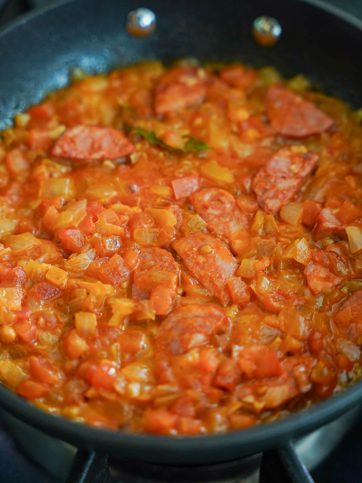 tomato, onion and chouico mixture in skillet.