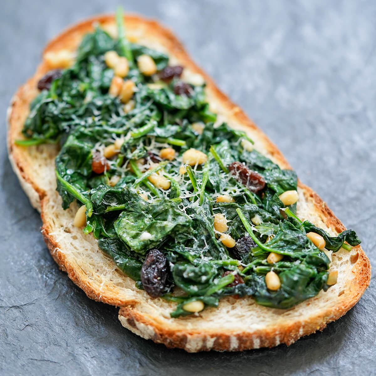 toast topped with spinach wilted with pine nuts and raisins with a little parmesan on top.