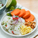 plate of Peruvian ceviche with corn and sweet potato on side.
