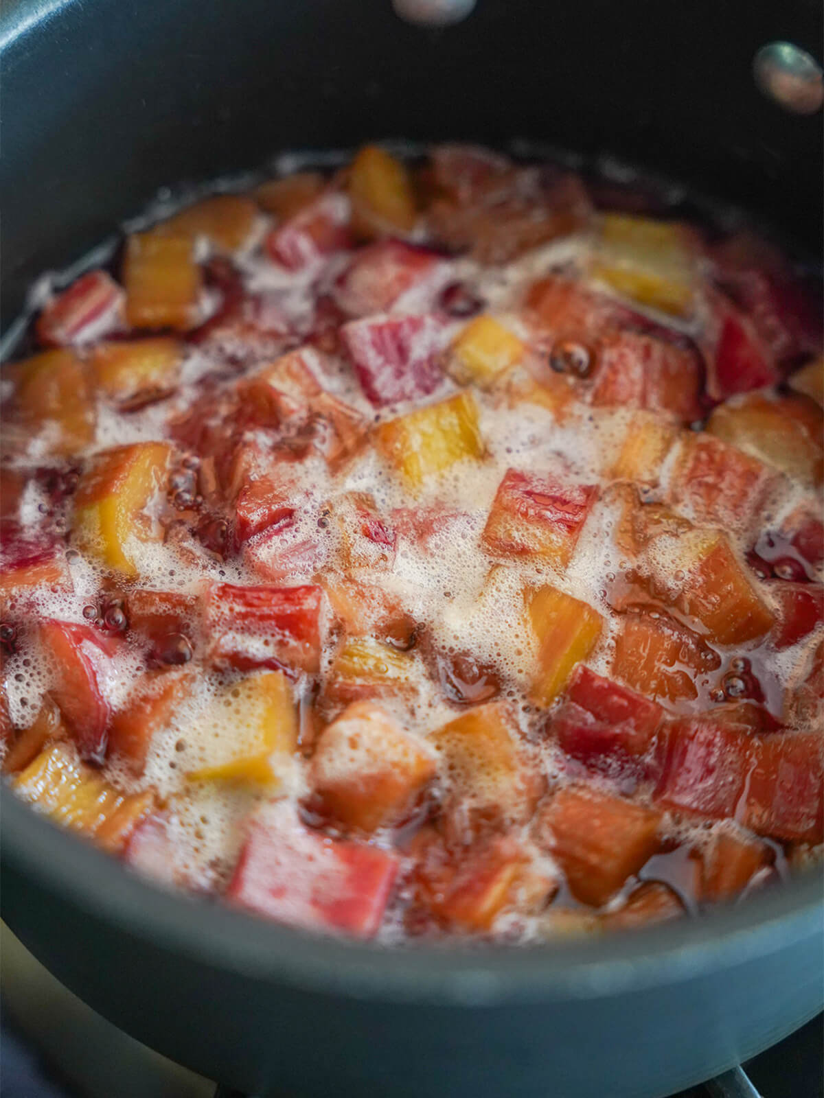 chopped rhubarb pieces cooking in pan.