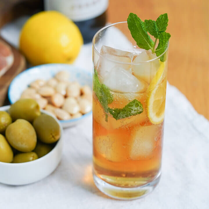glass of rebujito, sherry cocktail, loaded with ice and garnished with mint.