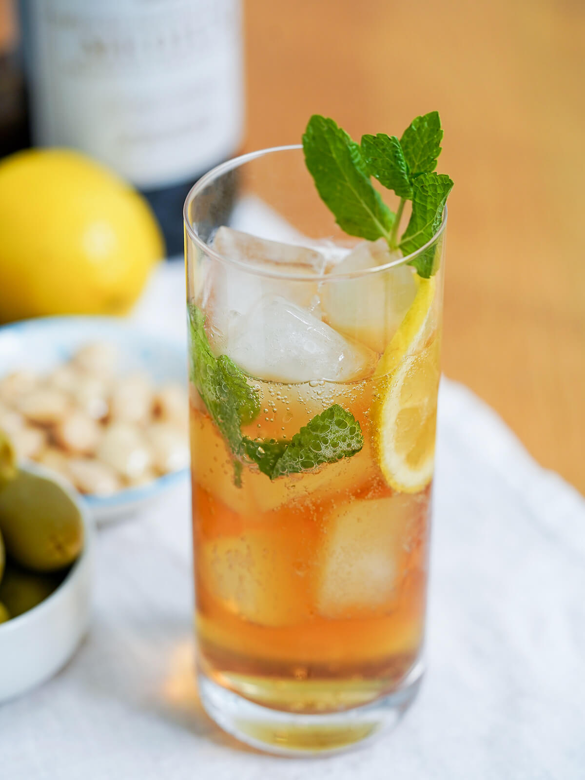 glass of rebujito, sherry cocktail with mint garnish and slice of lemon in glass with ice.