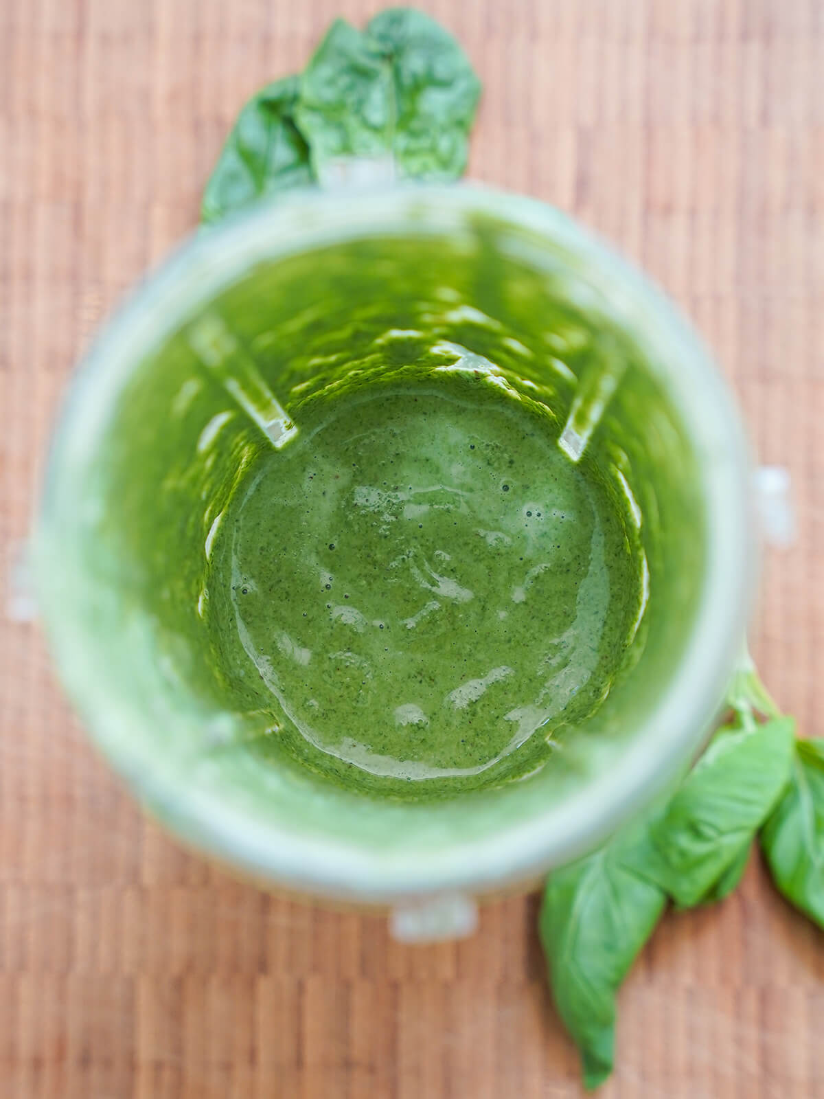 blender with blended up green sauce inside.