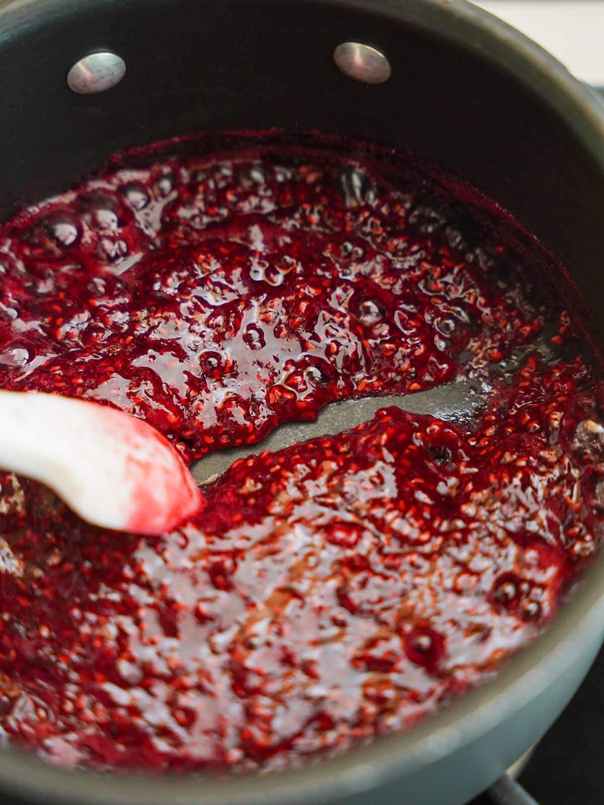 pulling spatula through jam to show open trail before it closes in behind.