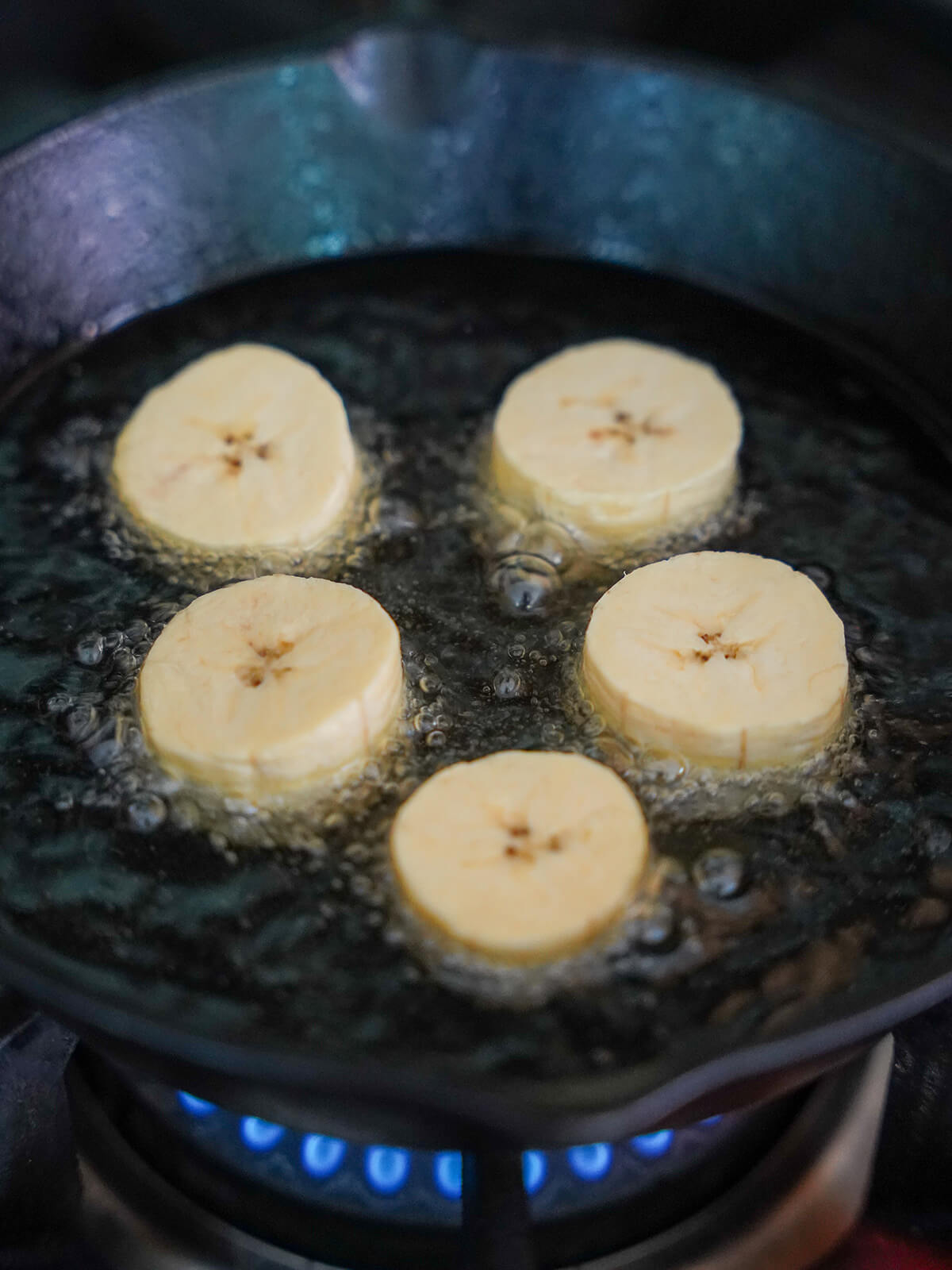 frying slices of plantain in oil.