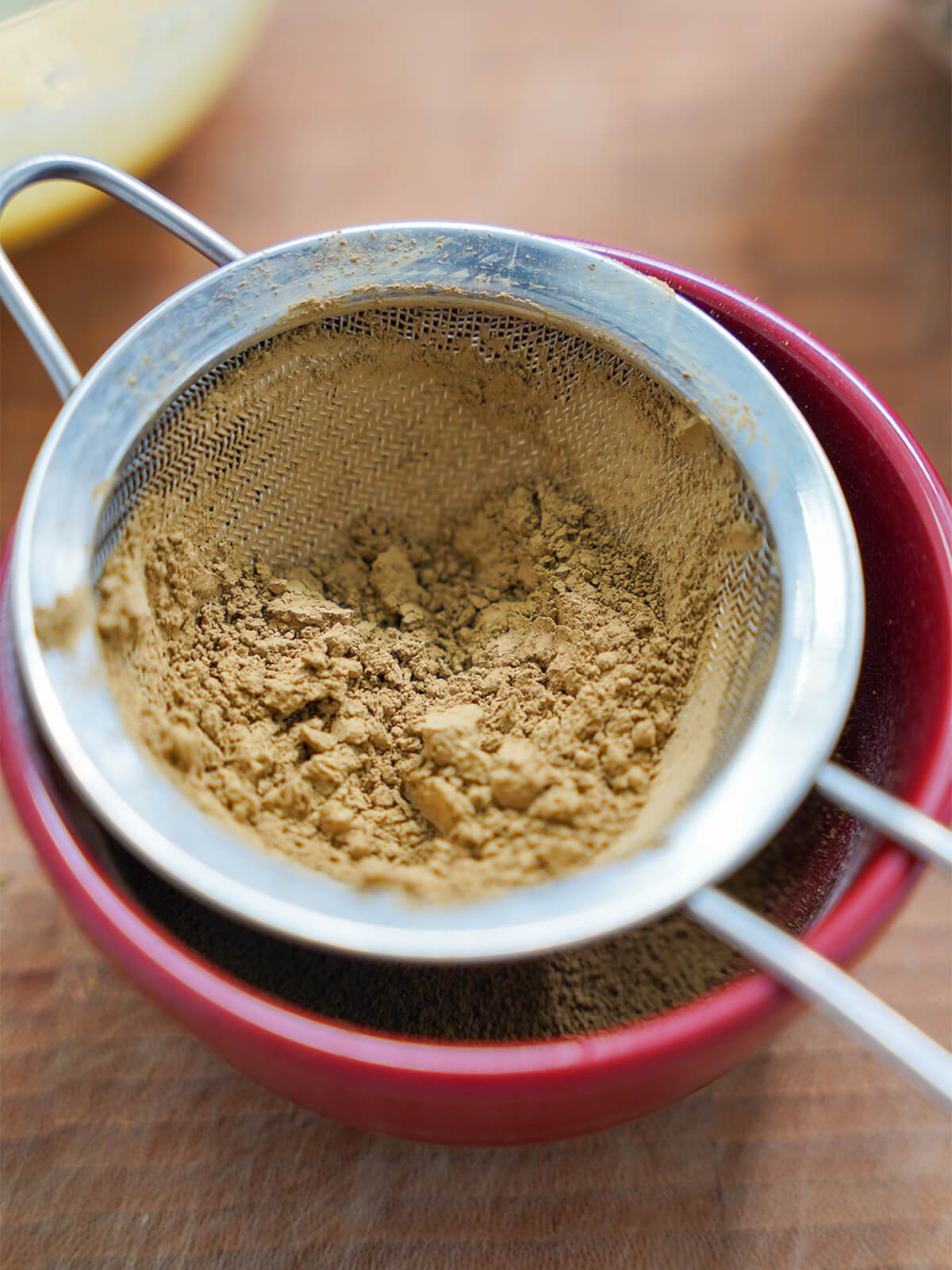 sifting hohicha powder sifting hojicha powder into small bowl.