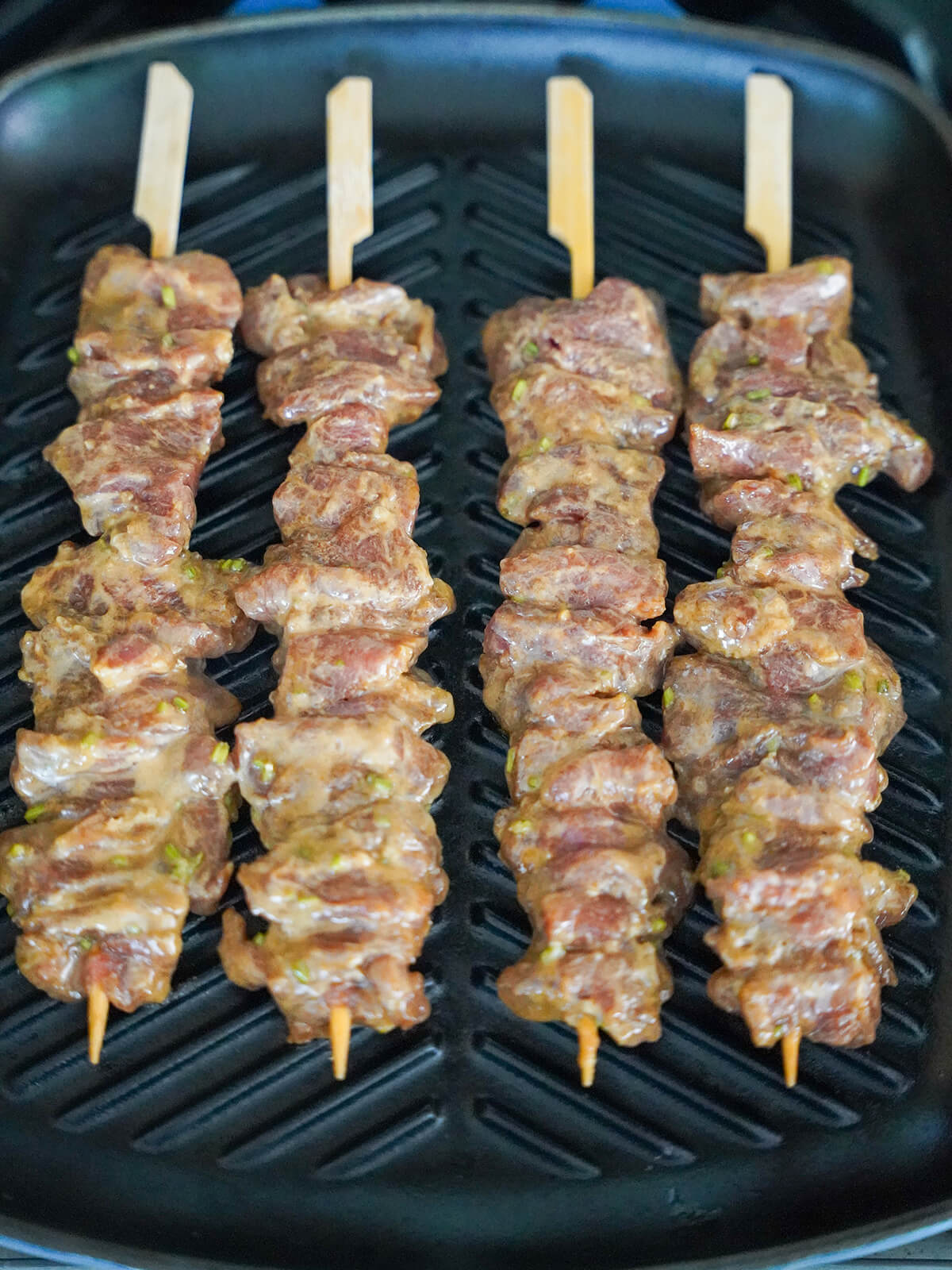 cooking moo ping, Thai marinated pork skewers cooking moo ping pork skewers on grill pan.