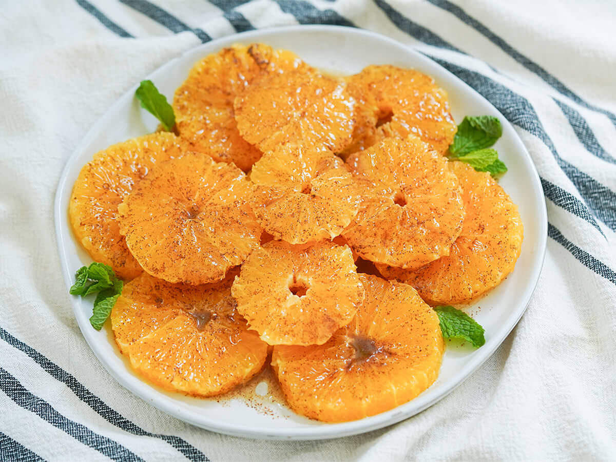 plate of Moroccan oranges with cinnamon garnished with mint.
