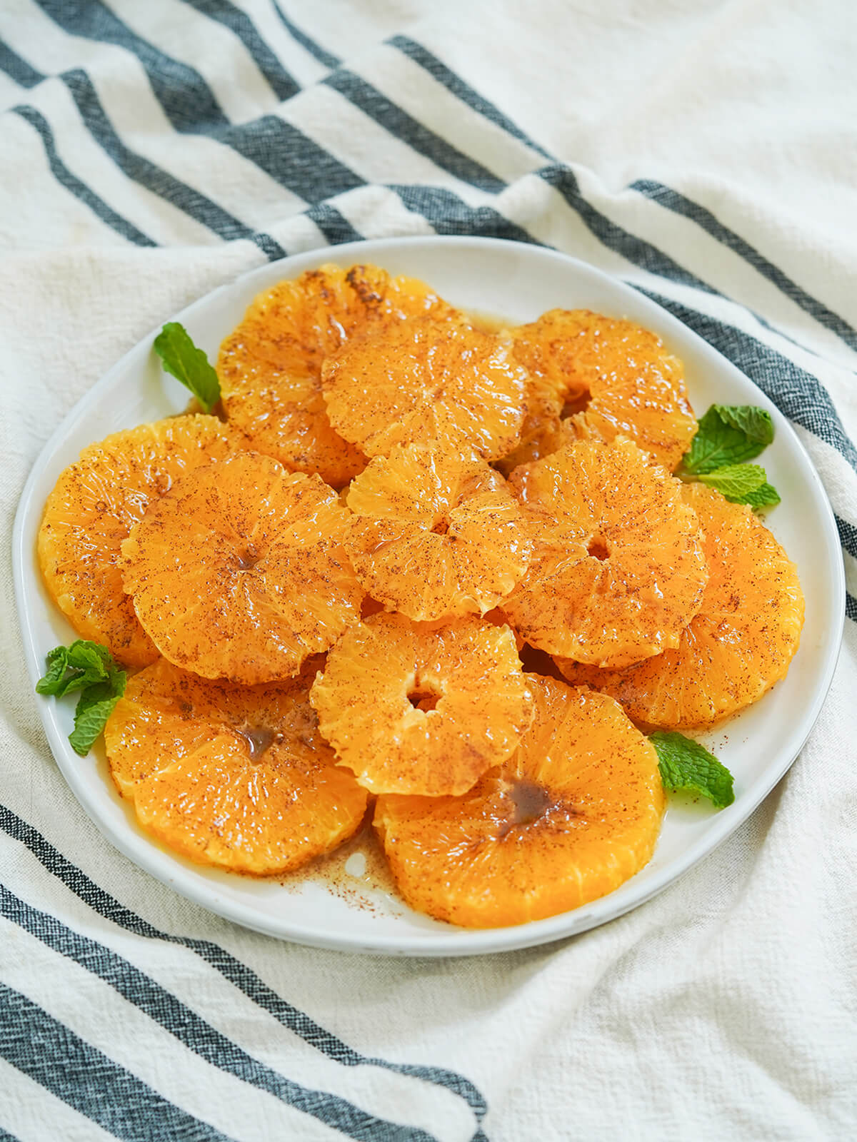 side view of a plate of Moroccan oranges with cinnamon.