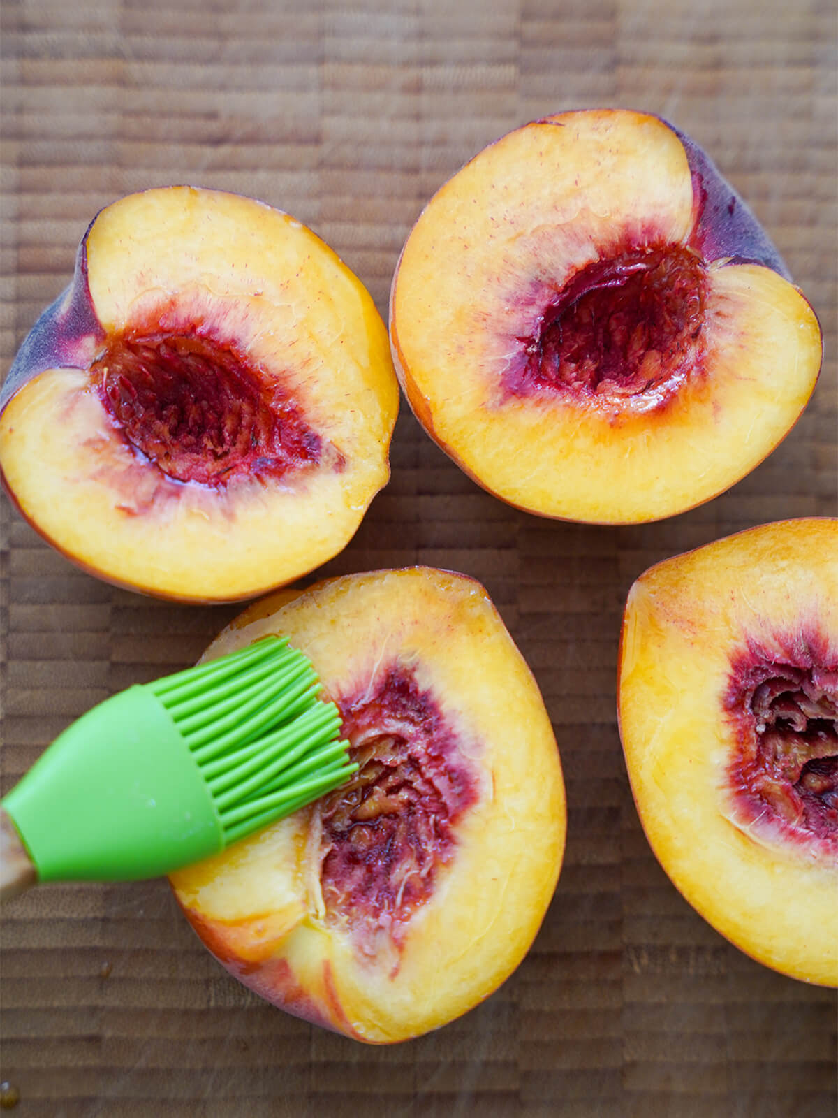 brushing halved peaches with oil.