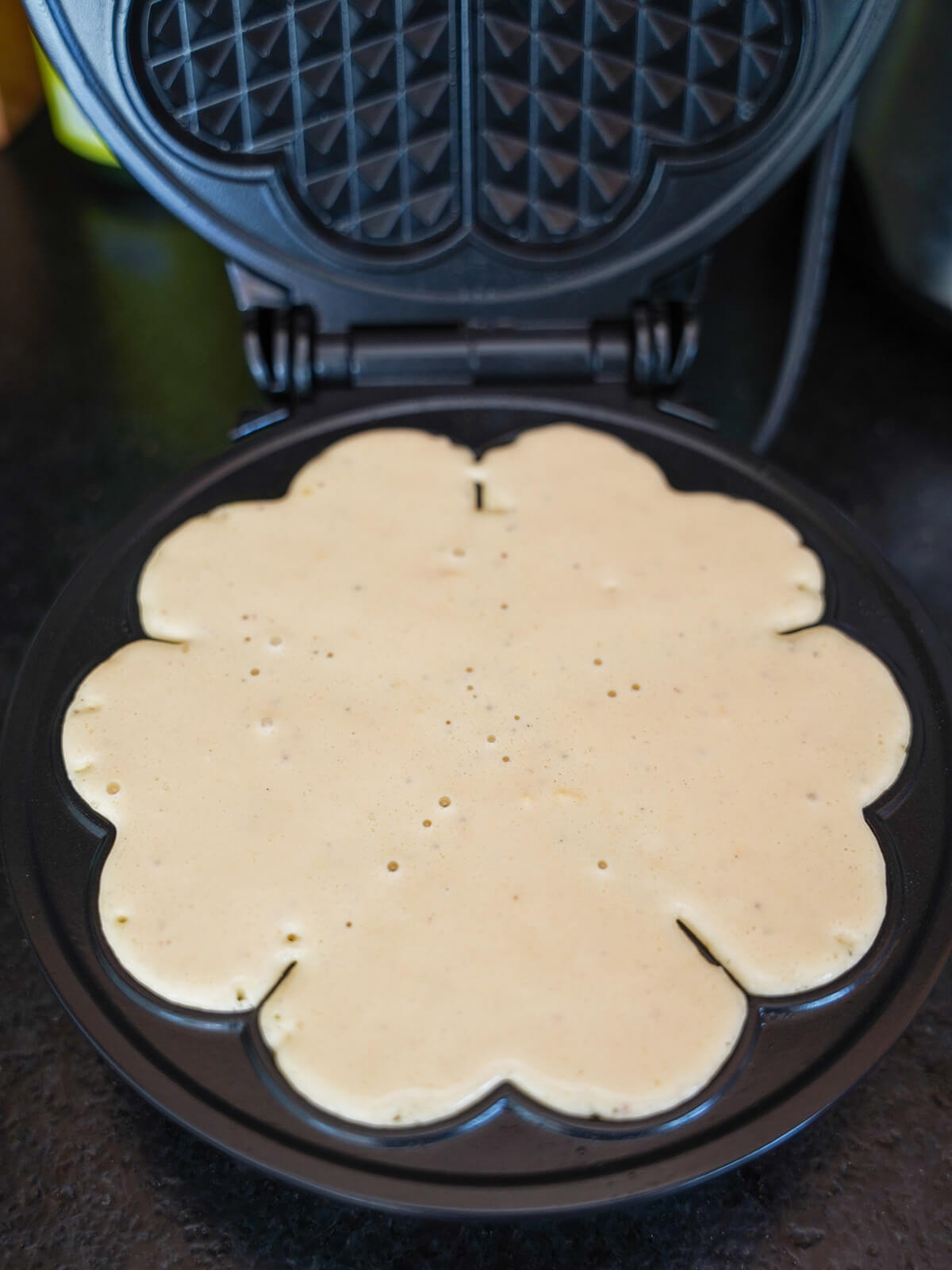 waffle batter in waffle maker before closing to cook.