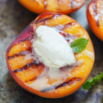 close up of a half grilled peach with mascarpone.