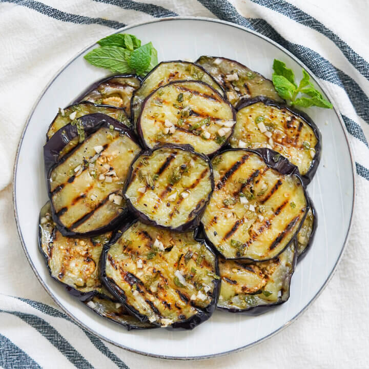 plate of marinated eggplant slices stacked together.