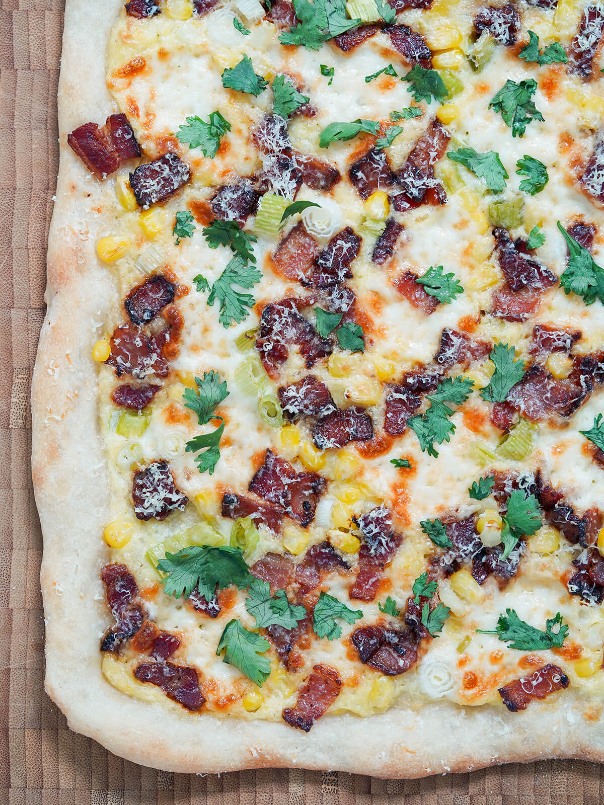 partial view of corn pizza with bacon.