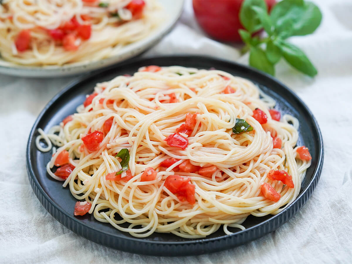 plate of plate of pasta with fresh tomatoes, spaghetti al pomodoro crudo plate of plate of pasta with fresh tomatoes, spaghetti al pomodoro crudo, from side.