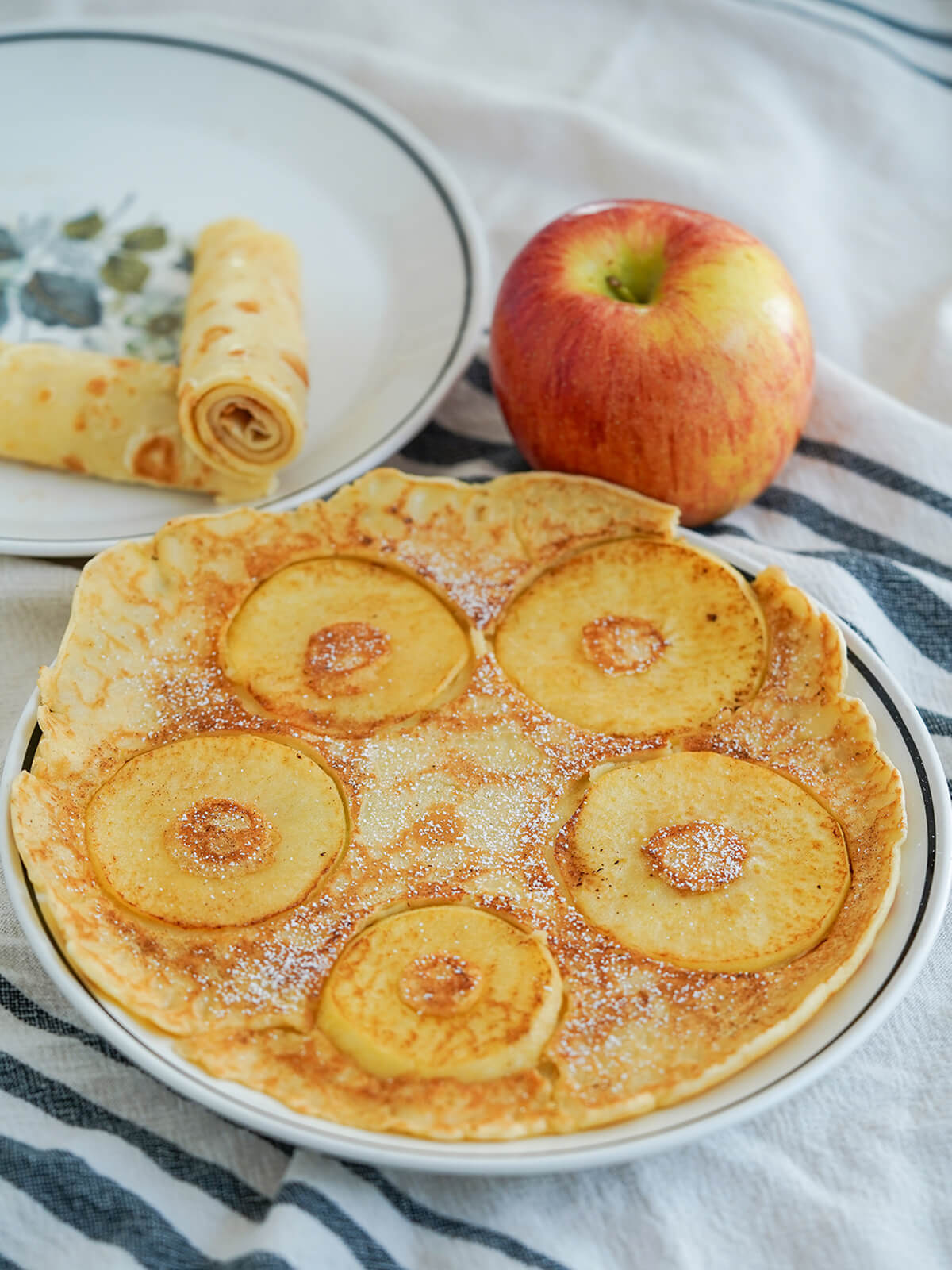 Pannekoeken Dutch pancakes, front with apples and behind rolled up.