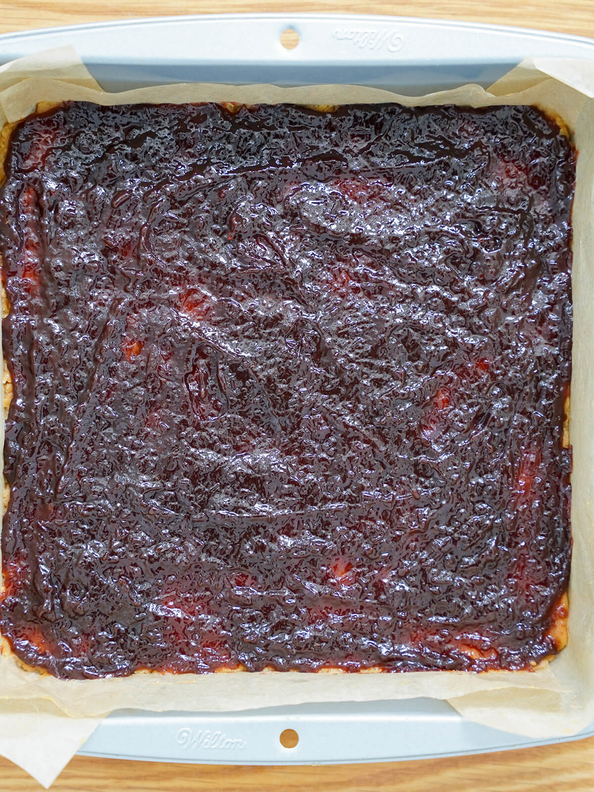 layer of jam spread over base in baking pan.