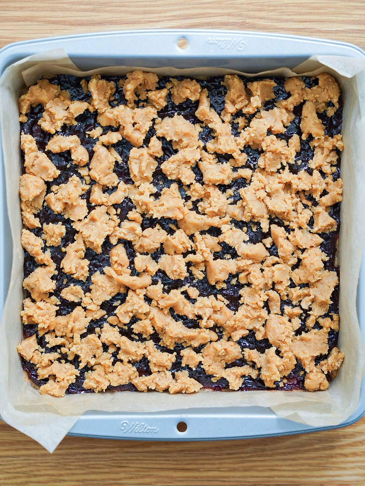 chunks of cookie dough topping over other layers before baking.