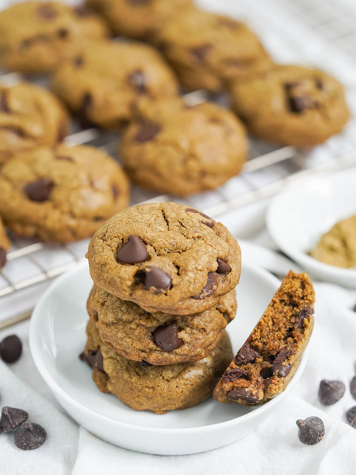 stack of hojicha chocolate chip cookies with more on rack behind.