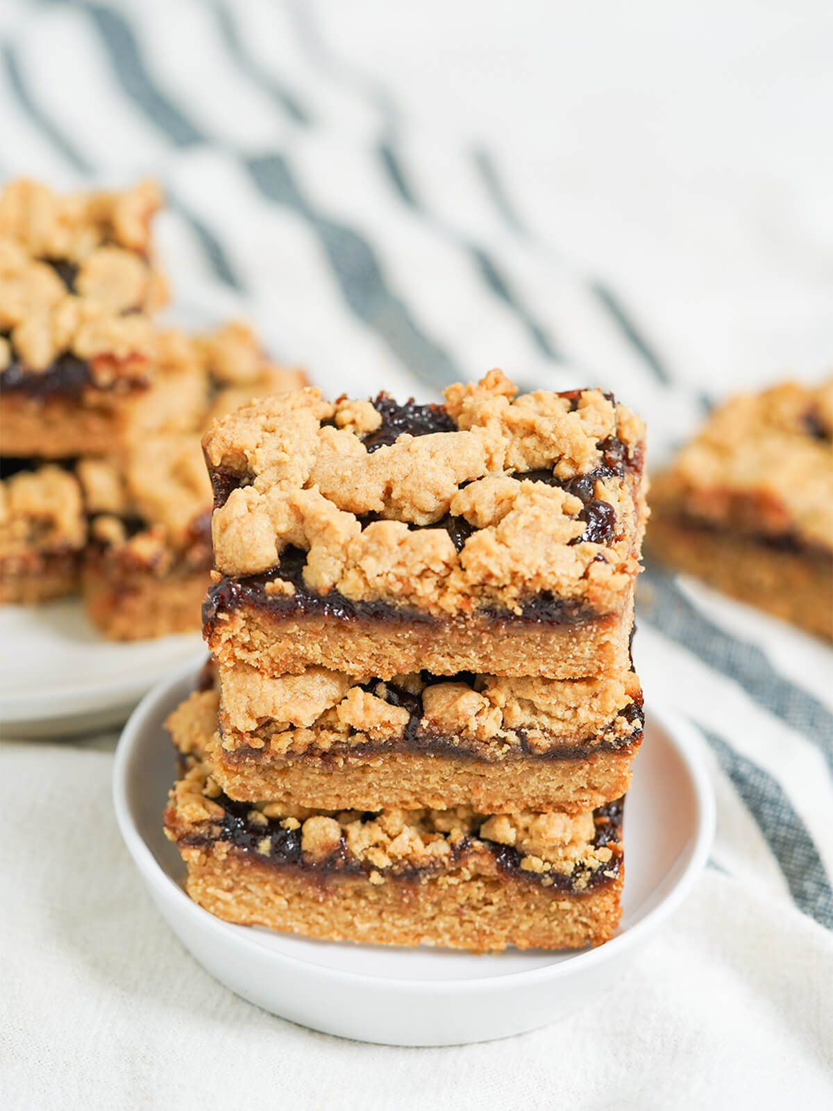 stack of three peanut butter and jelly bars with more behind.