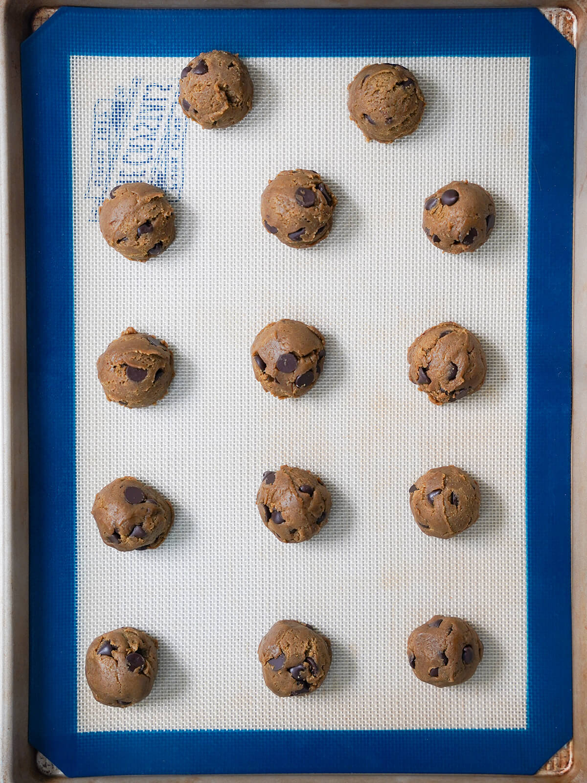 hojicha chocolate chip cookies before baking balls of cookie dough on lined baking sheet