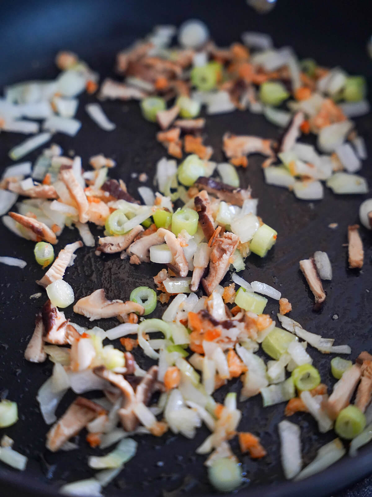 start cooking aromatics for Taiwanese pumpkin rice vermicelli noodles cooking onion, mushroom, dried shrimp in skillet to give aromatic base.