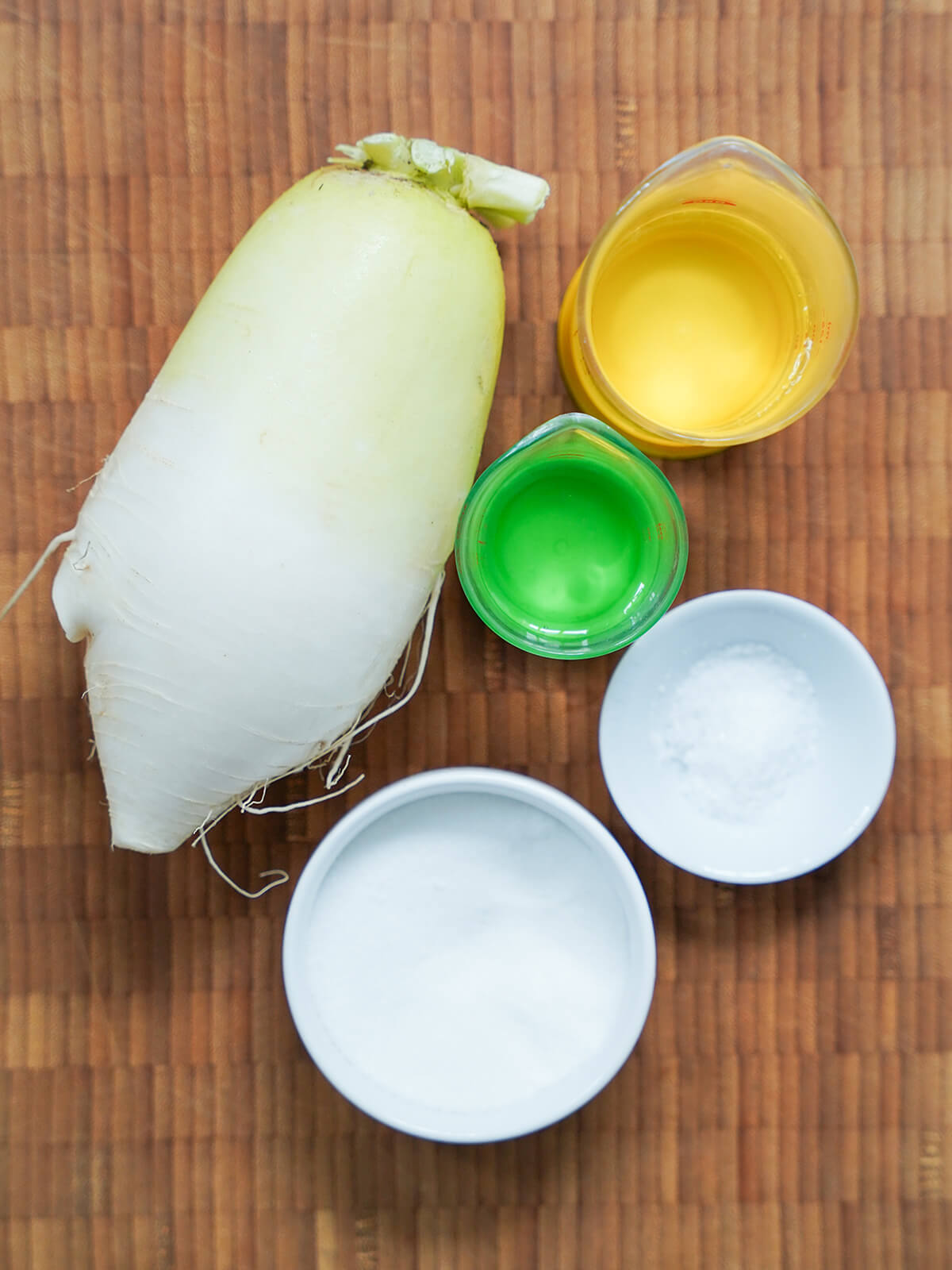 ingredients for Korean pickled radish slices Korean radish, dishes with salt and sugar, measures of water and vinegar.